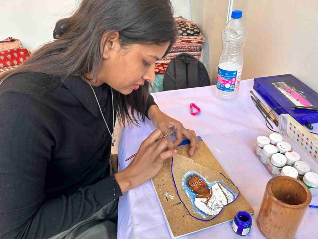 पीपल के पत्ते पर राष्ट्रपति की तस्वीर बनाते हुए साक्षी